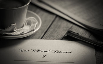 Gordon & Sykes sepia black and white photo of team paper and pen on wooden table surface above Learn More heading